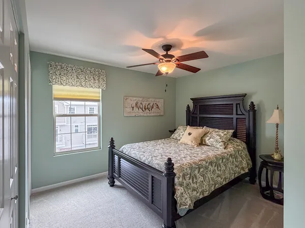 a bedroom with a bed chandelier and a window