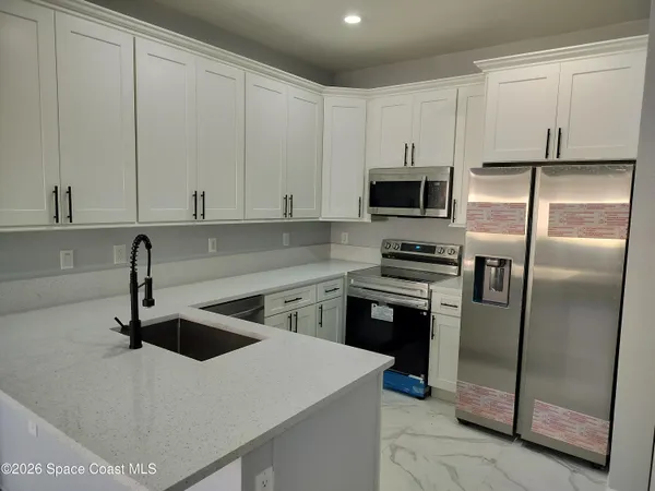 a kitchen with a refrigerator and a stove