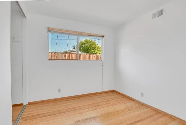 a view of an empty room with wooden floor