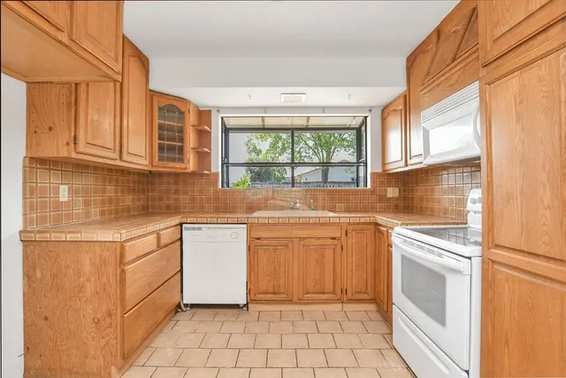 a kitchen with a stove sink and cabinets