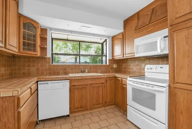 an empty room with windows and fireplace