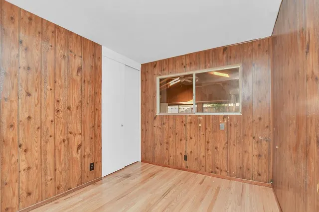 a view of a room with wooden floor and a wooden door