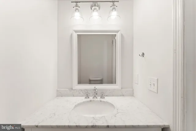 a bathroom with a granite countertop sink and a mirror