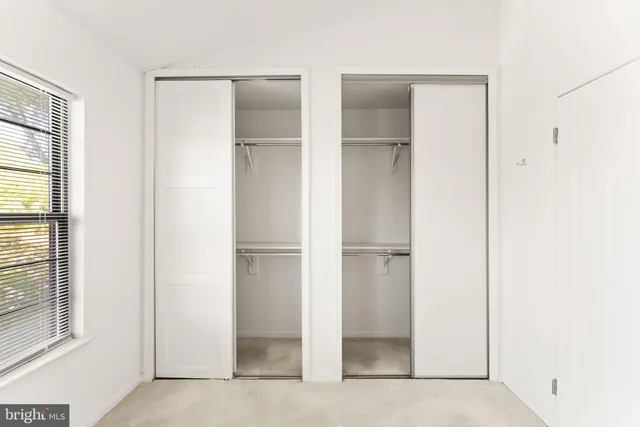 a view of walk in closet with empty racks