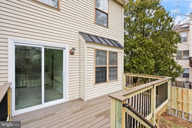 a view of a house with wooden deck and a yard