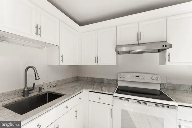 a kitchen with white cabinets and white appliances