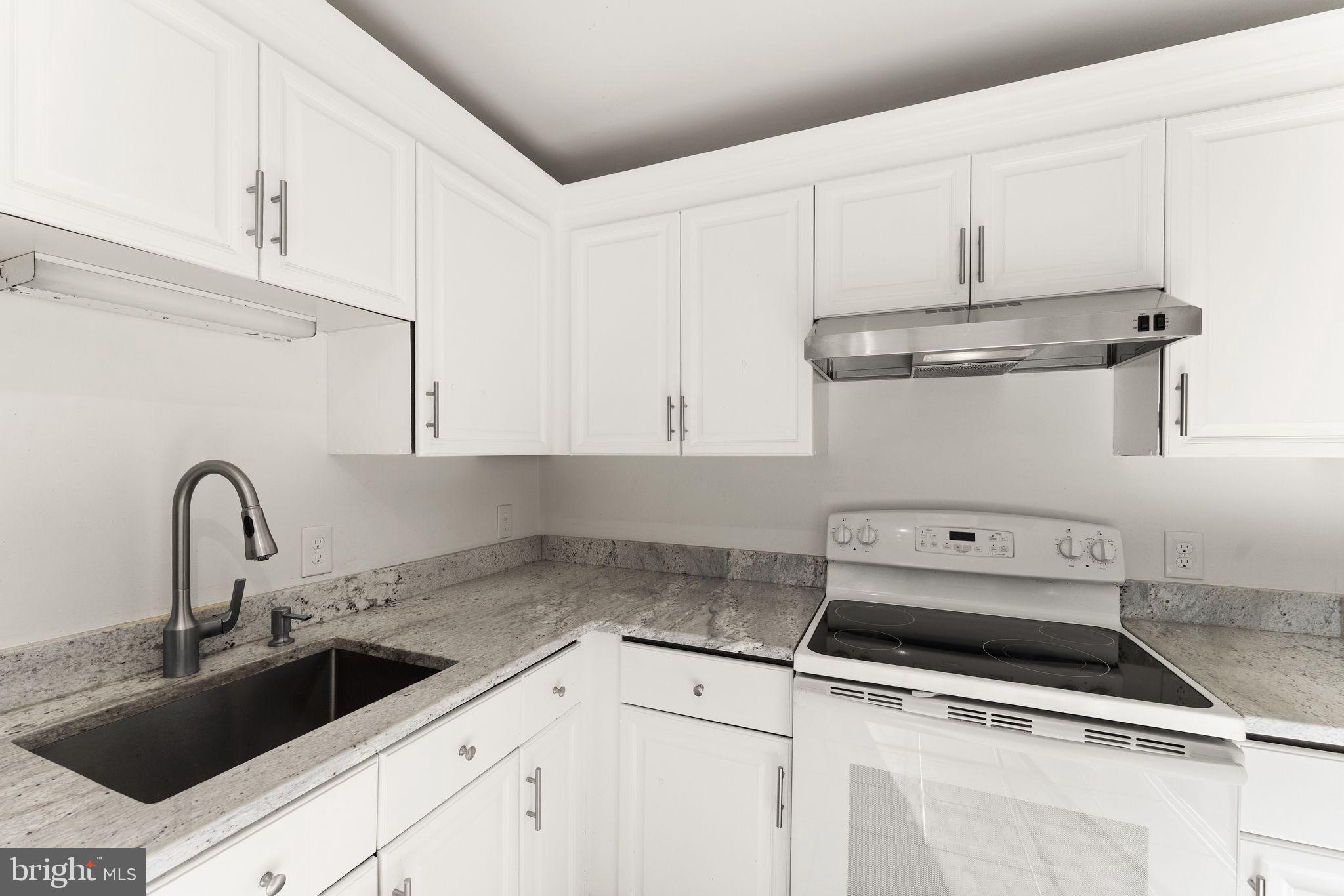 6001 Little Brook Court Clifton, VA 20124 - Photo 4 of 46 a kitchen with white cabinets and white appliances