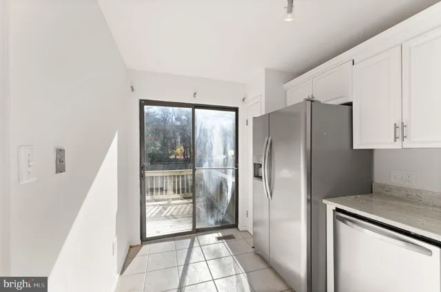 a view of a kitchen with refrigerator and mirror