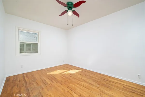 a view of a room with wooden floor and a ceiling fan