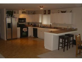 7707 East Irwin Ranch Road Prescott Valley, AZ 86315 - Photo 3 of 12 a kitchen with a sink refrigerator and cabinets