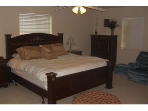 7707 East Irwin Ranch Road Prescott Valley, AZ 86315 - Photo 6 of 12 a bed sitting in a bedroom next to a window with dresser