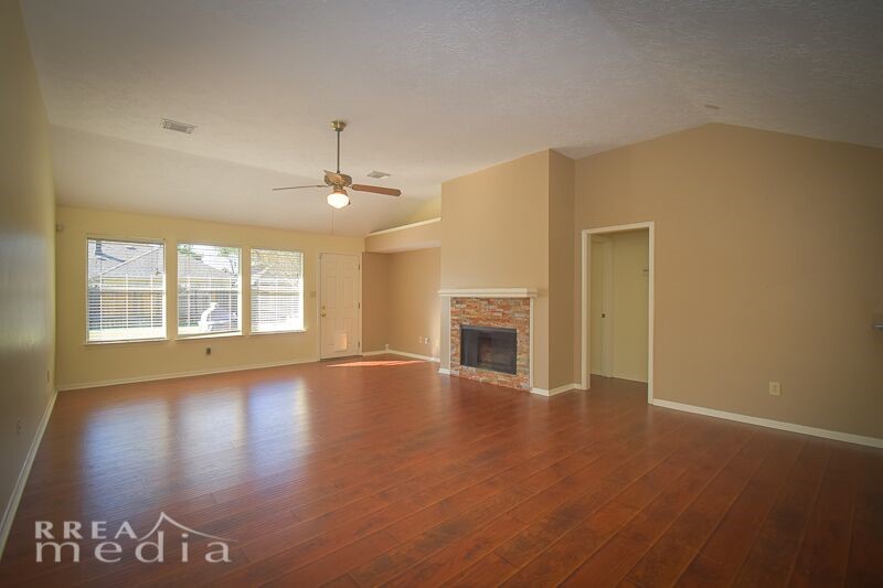 19723 Glenfinch Lane Spring, TX 77379 - Photo 7 of 39 Large living room has scraped, hardwood looking laminate flooring