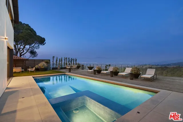 a view of a house with pool and chairs