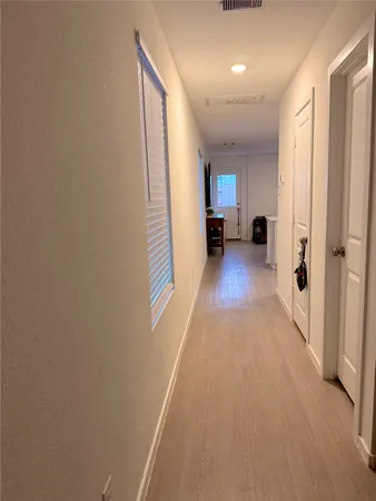 a view of a hallway with wooden floor and a living room
