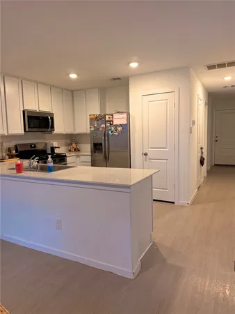 a kitchen with stainless steel appliances a refrigerator sink and cabinets