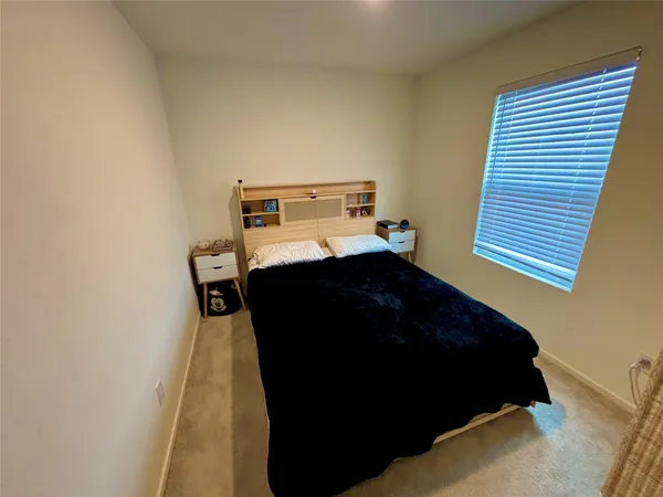 a bed sitting in a bedroom next to a window