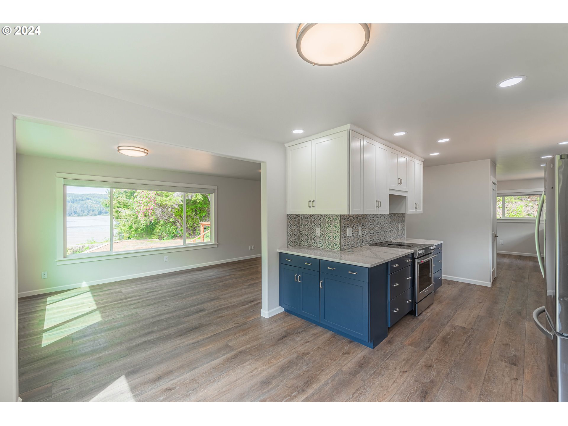 66013 North Bay Road North Bend, OR 97459 - Photo 11 of 48 a kitchen with stainless steel appliances granite countertop a sink a stove and a wooden floors