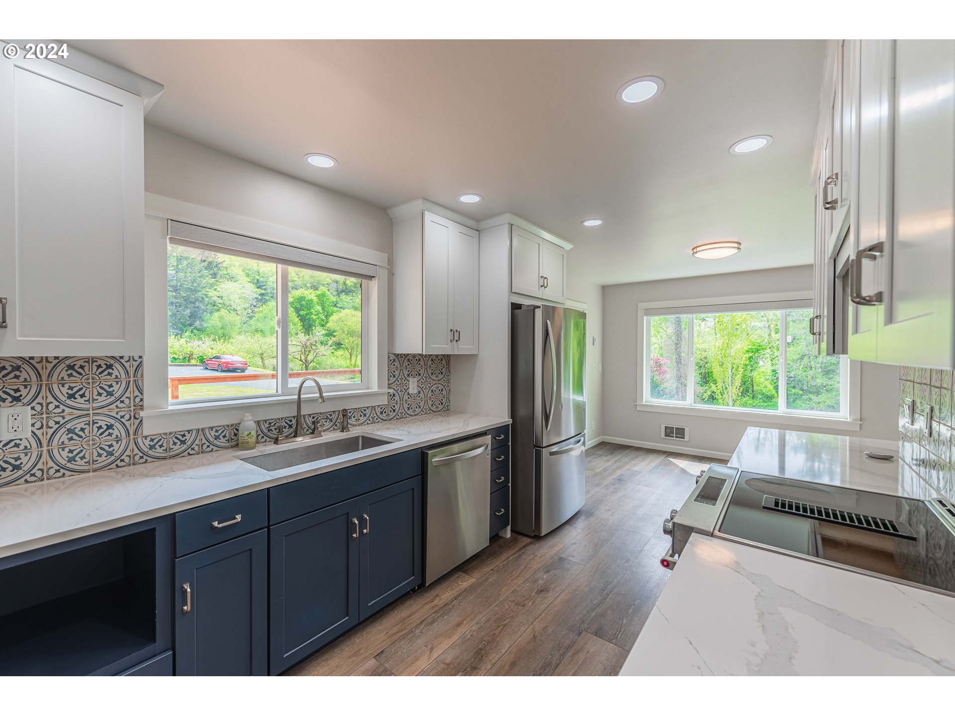 66013 North Bay Road North Bend, OR 97459 - Photo 15 of 48 a kitchen with stainless steel appliances granite countertop a refrigerator a sink dishwasher a stove and white countertops with wooden floor