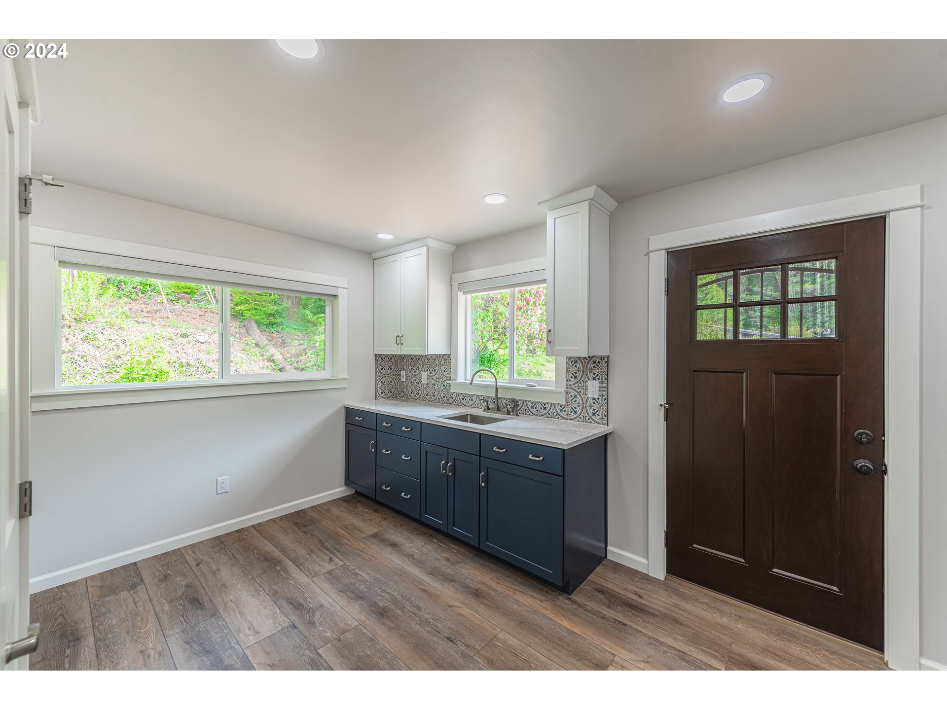 66013 North Bay Road North Bend, OR 97459 - Photo 17 of 48 a kitchen with granite countertop a stove a sink a window and wooden cabinets