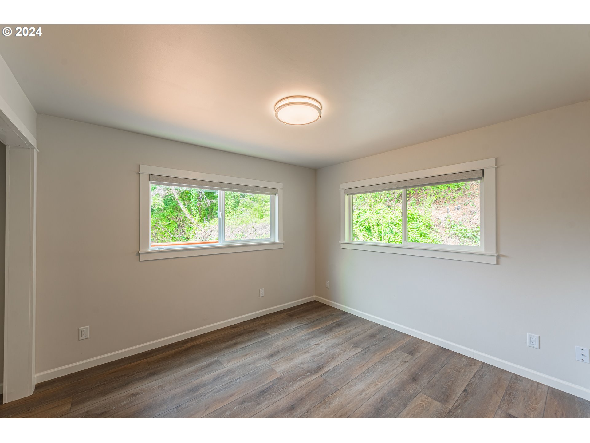 66013 North Bay Road North Bend, OR 97459 - Photo 19 of 48 a view of an empty room with wooden floor and a window
