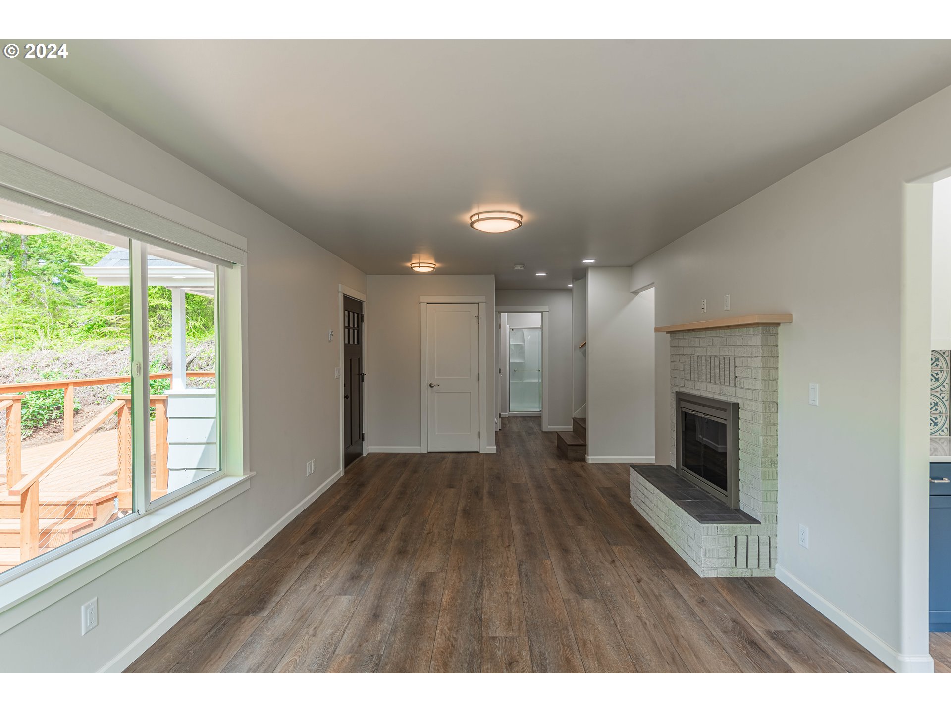 66013 North Bay Road North Bend, OR 97459 - Photo 20 of 48 a view interior of a house with wooden floor fireplace and windows