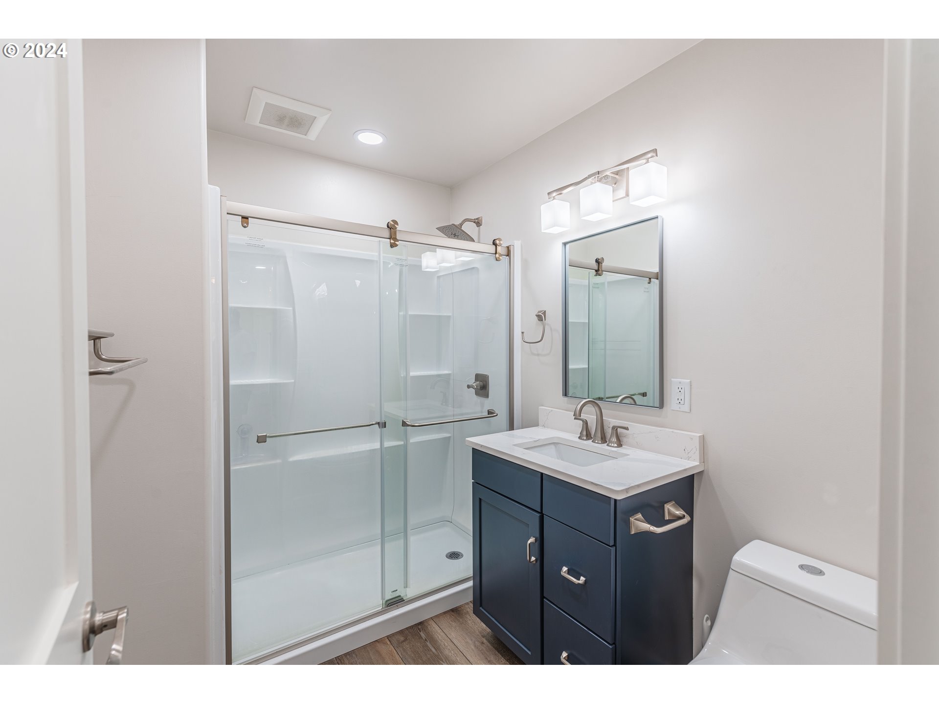 66013 North Bay Road North Bend, OR 97459 - Photo 21 of 48 a bathroom with a sink mirror and a shower