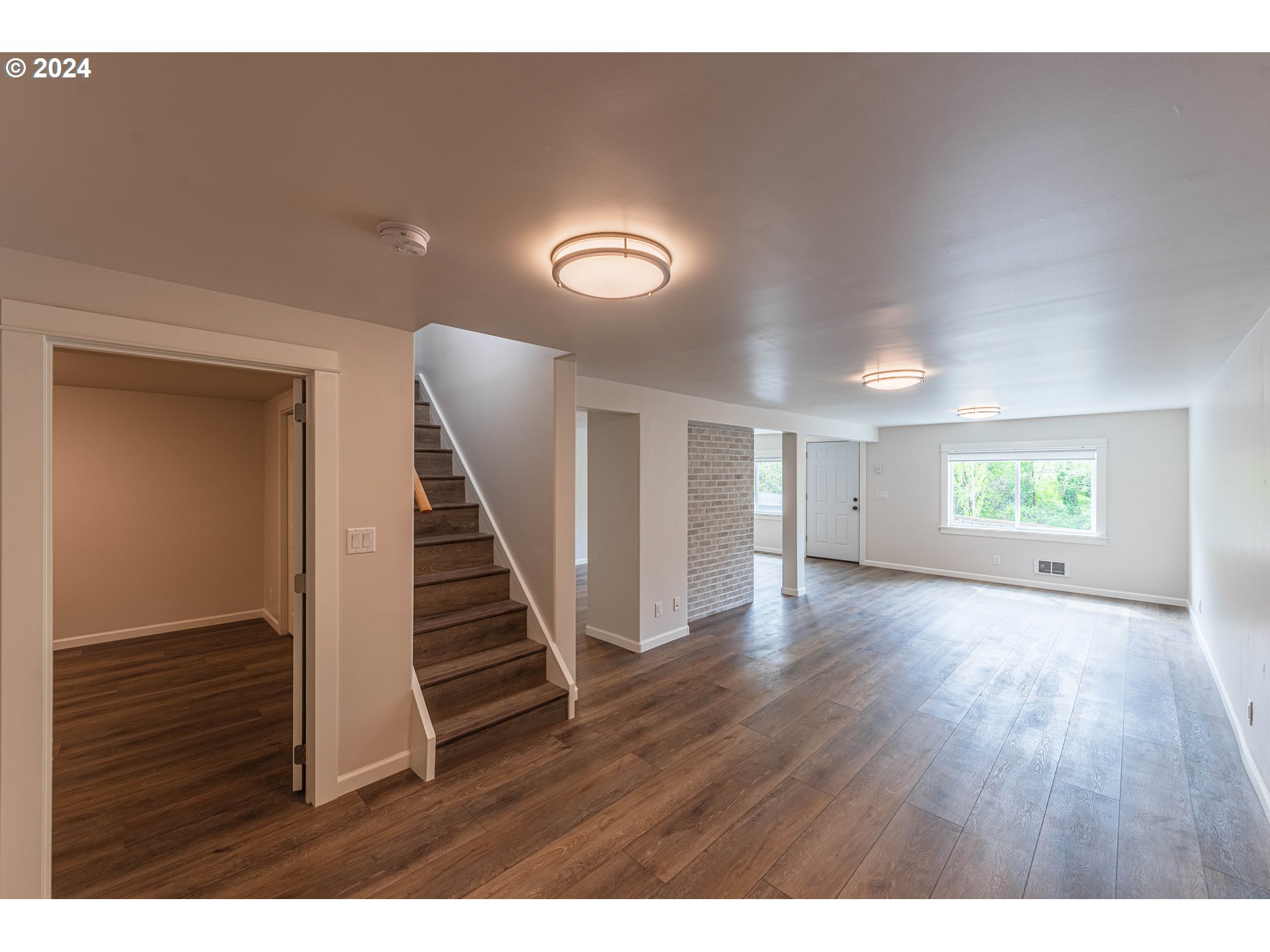 66013 North Bay Road North Bend, OR 97459 - Photo 34 of 48 a view of an empty room with wooden floor and stairs