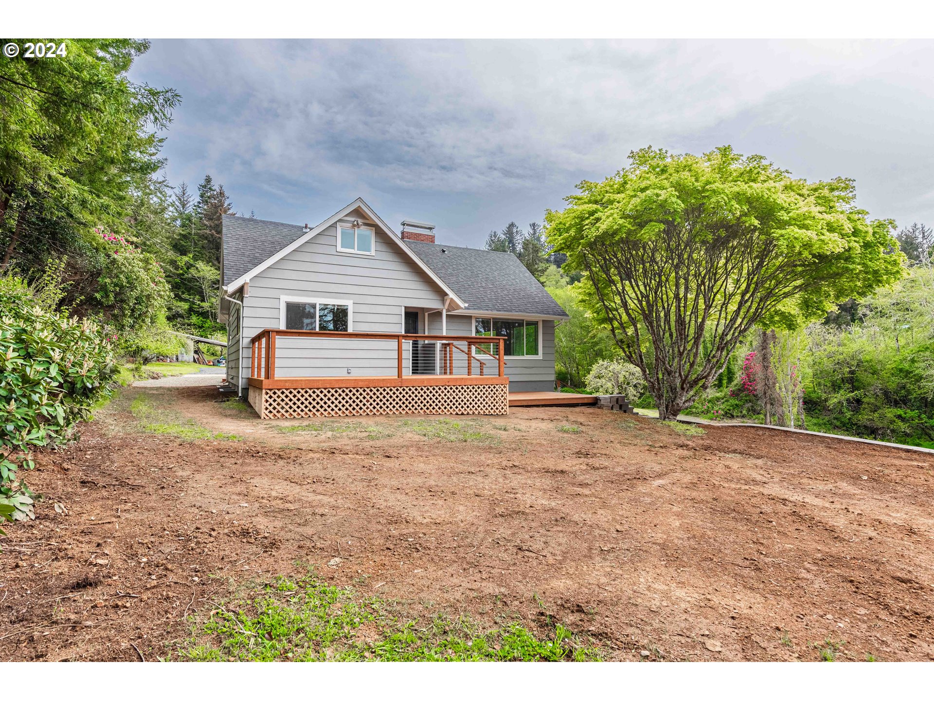 66013 North Bay Road North Bend, OR 97459 - Photo 44 of 48 a front view of a house with a garden and yard