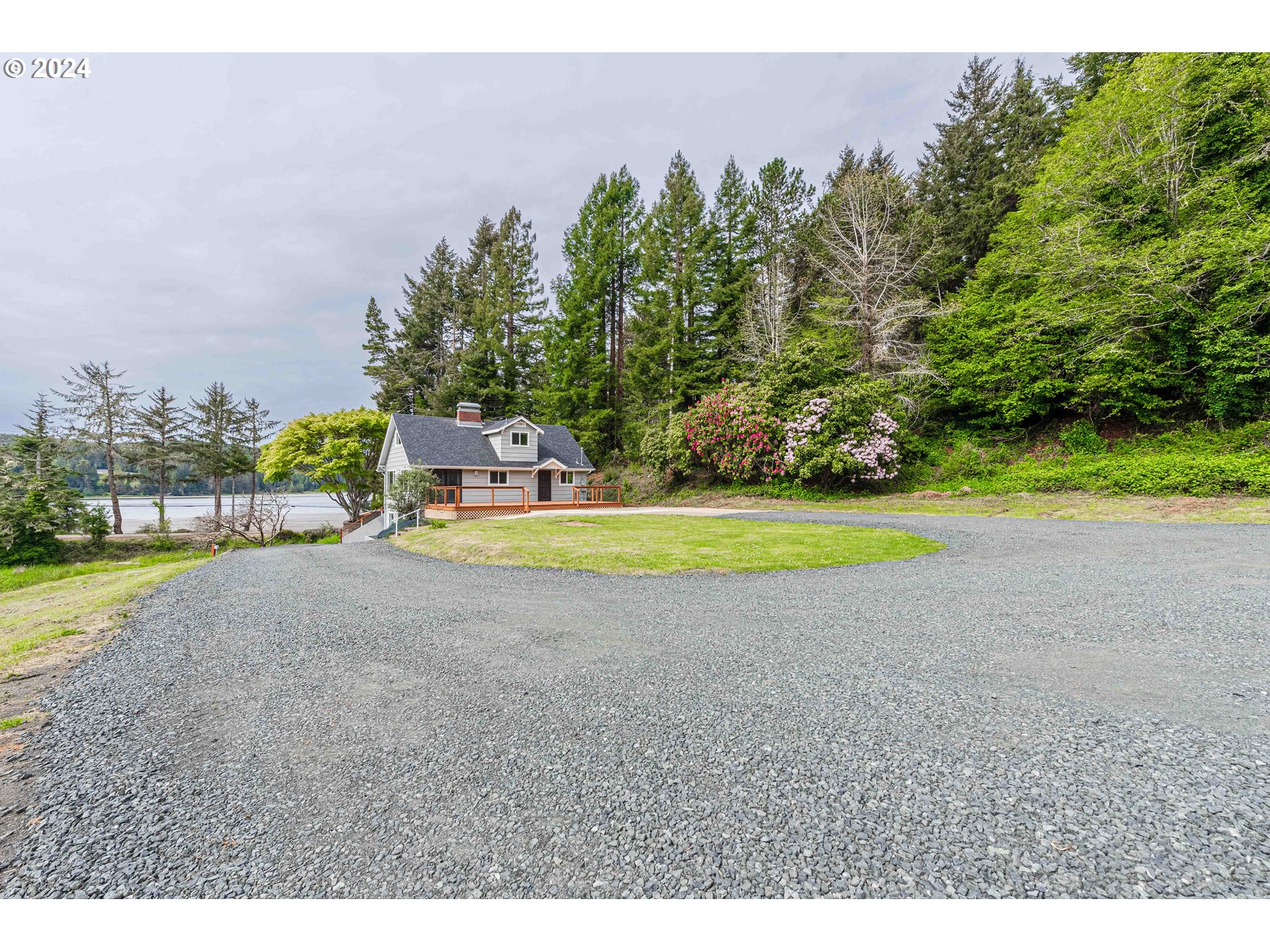 66013 North Bay Road North Bend, OR 97459 - Photo 6 of 48 a view of a swimming pool and trees in the background