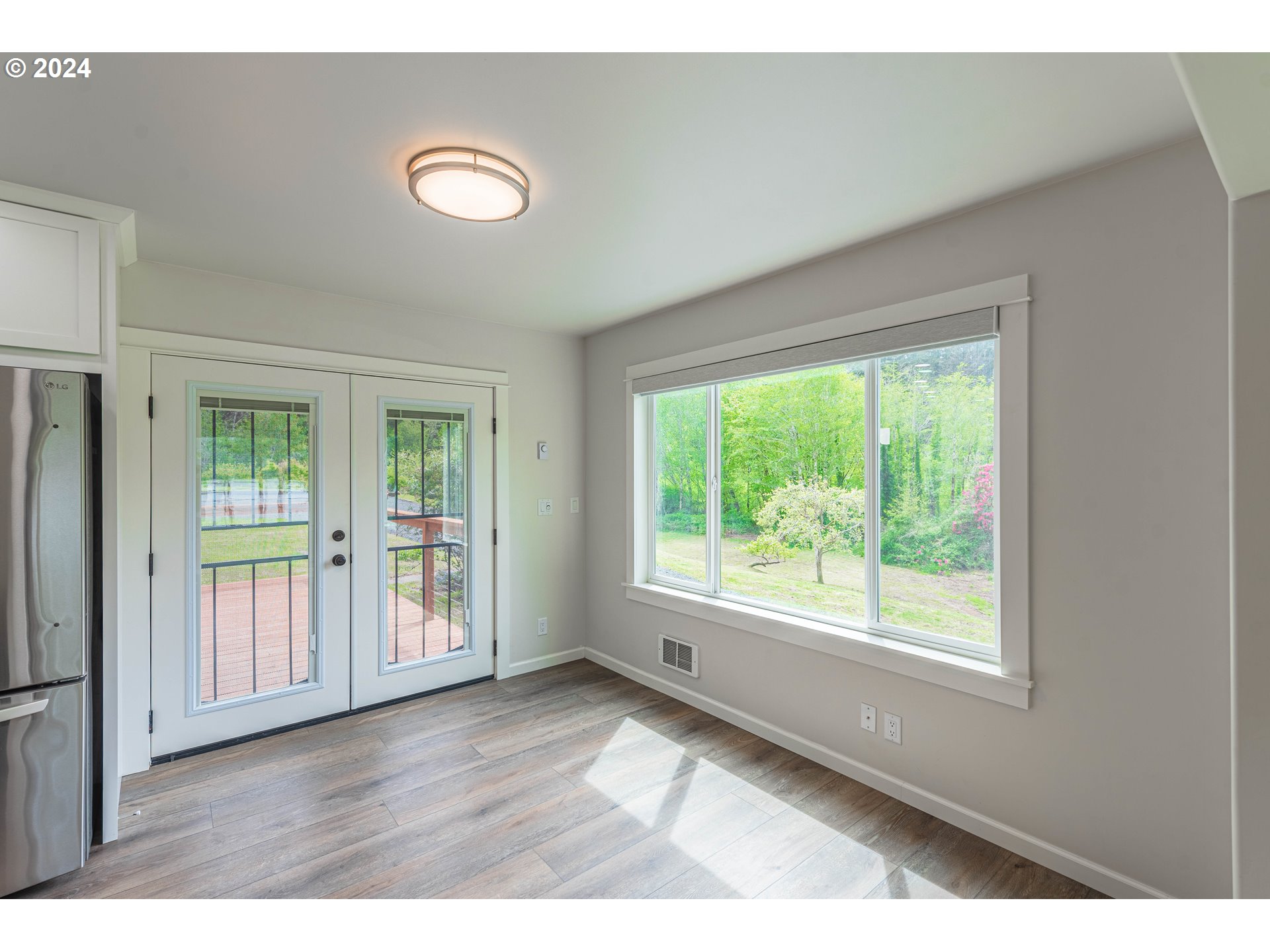 66013 North Bay Road North Bend, OR 97459 - Photo 10 of 48 a view of an empty room with wooden floor and a window