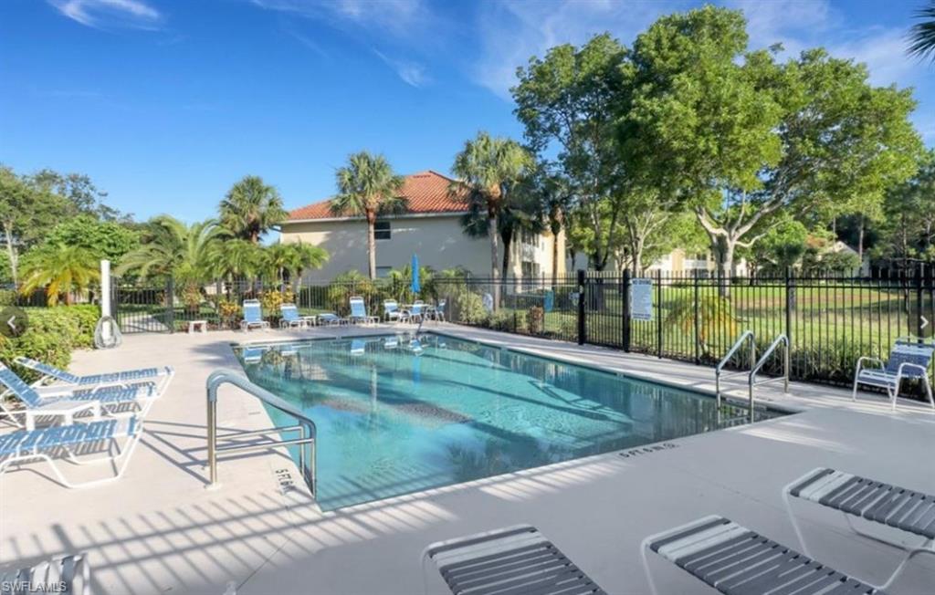 280 Robin Hood Circle, Unit 102 Naples, FL 34104 - Photo 19 of 24 a view of a swimming pool with a patio and a yard
