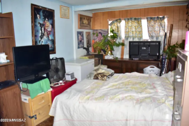 a bedroom with a bed a flat screen tv and a fireplace