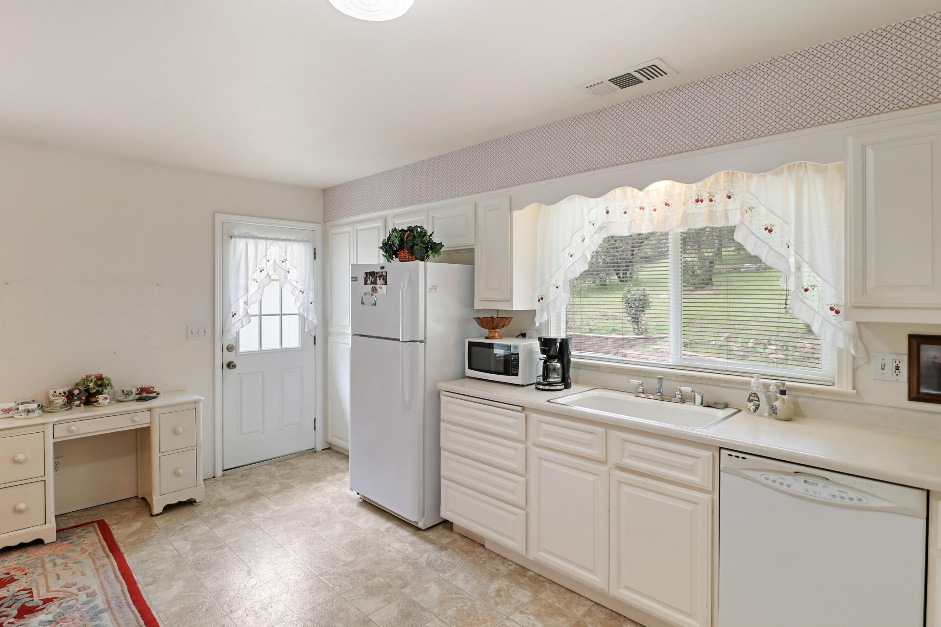 9400 Placer Road Redding, CA 96001 - Photo 14 of 52 a kitchen with white cabinets and white appliances