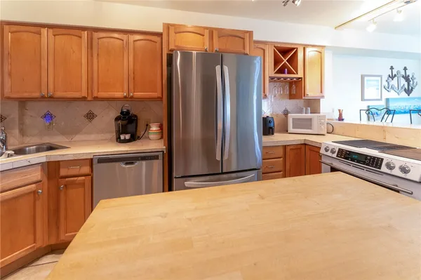 a kitchen with stainless steel appliances granite countertop a refrigerator and a sink