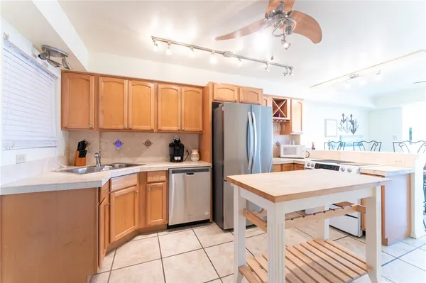 a kitchen with a sink a refrigerator and cabinets