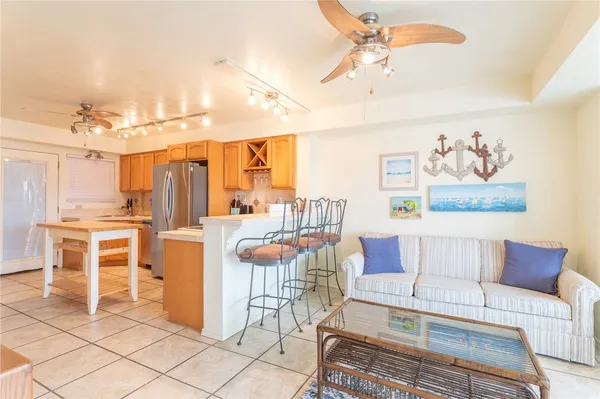 a living room with furniture a dining table and chairs with kitchen view