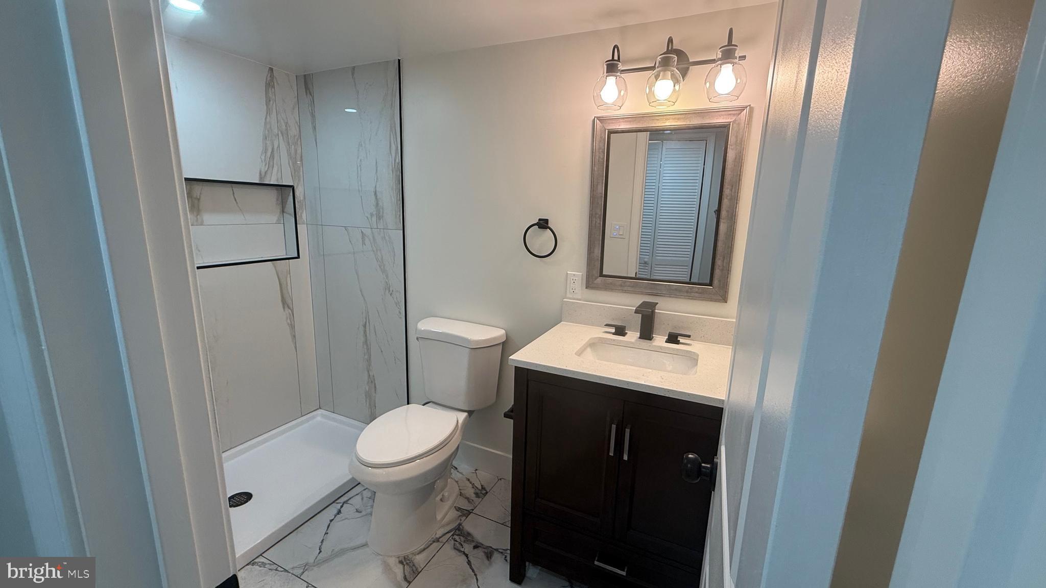 3802 Rokeby Road Baltimore, MD 21229 - Photo 8 of 16 a bathroom with a sink a toilet and a mirror