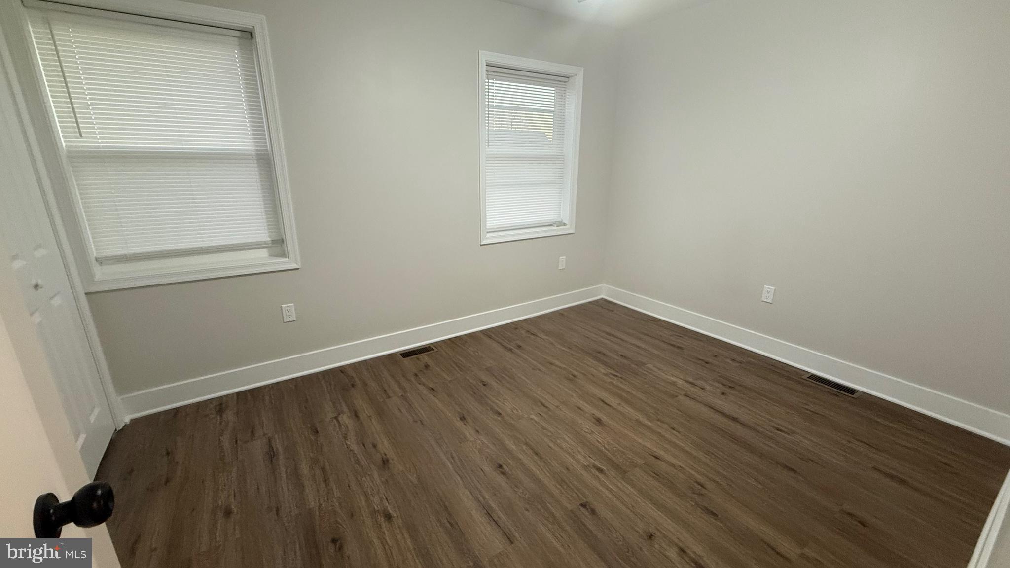3802 Rokeby Road Baltimore, MD 21229 - Photo 9 of 16 an empty room with wooden floor and windows