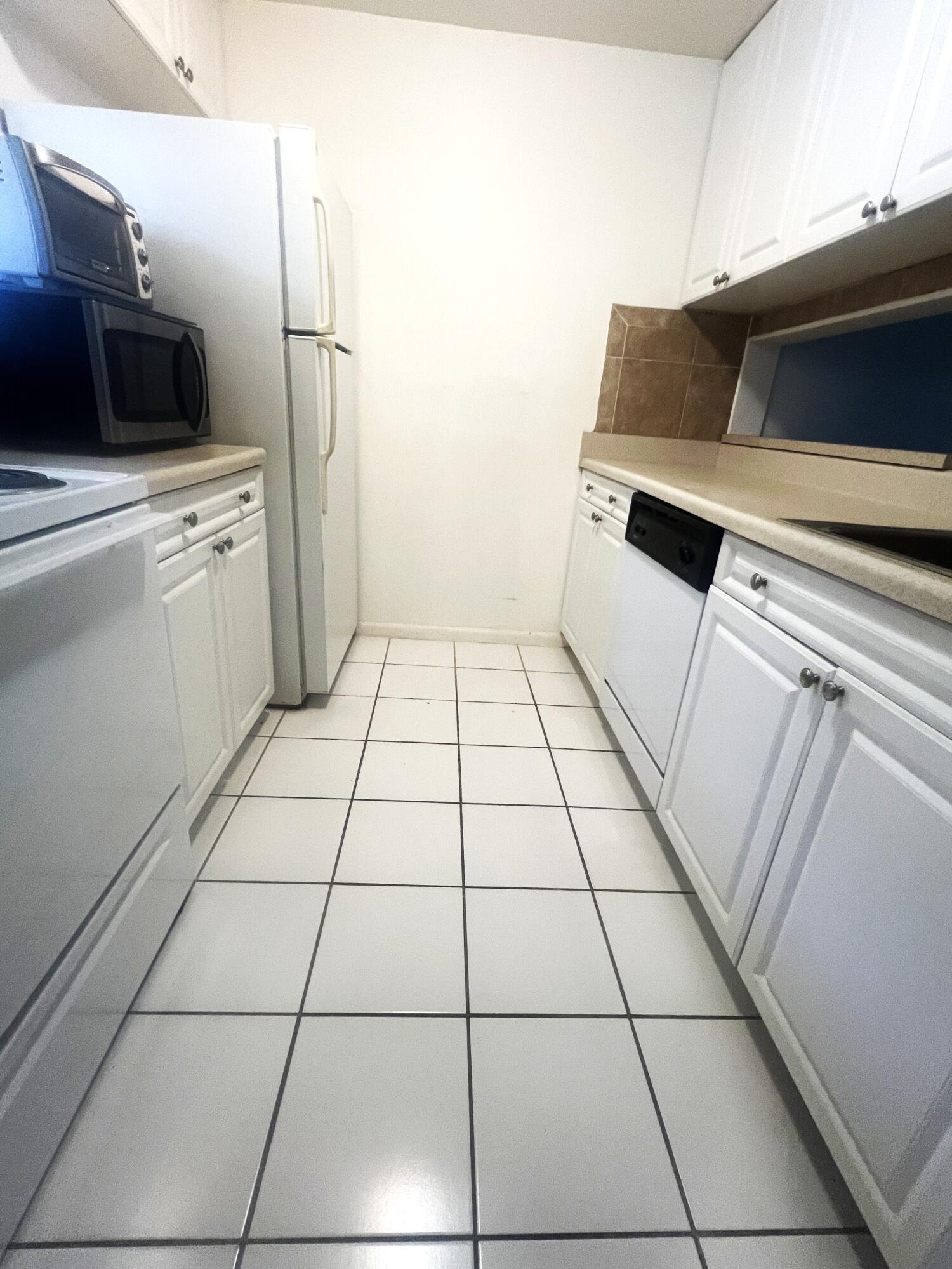 812 Southwest 9th St Circle, Unit 103 Boca Raton, FL 33486 - Photo 4 of 14 a kitchen with a sink and a stove top oven