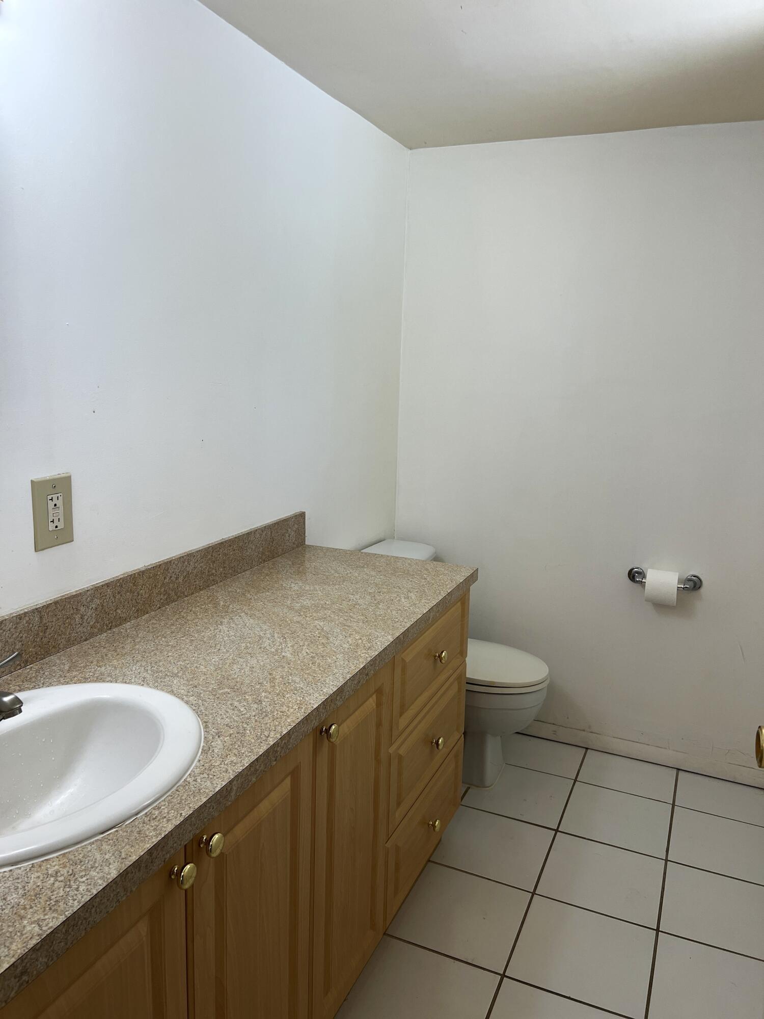 812 Southwest 9th St Circle, Unit 103 Boca Raton, FL 33486 - Photo 6 of 14 a bathroom with a granite countertop sink and toilet