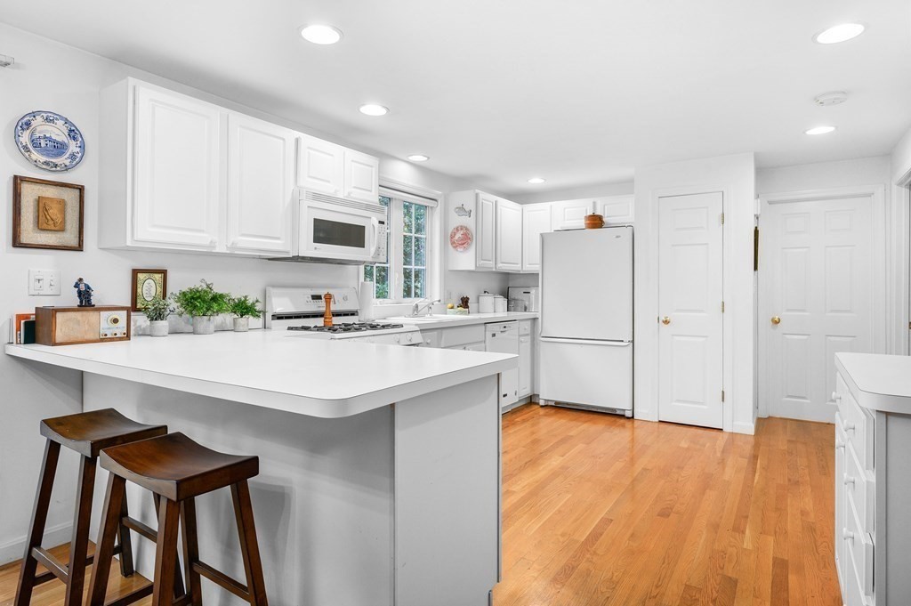120 Queen Anne Road Harwich, MA 02645 - Photo 10 of 35 a kitchen with stainless steel appliances white cabinets and wooden floor