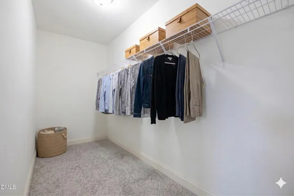 a view of walk in closet with clothes and shoes
