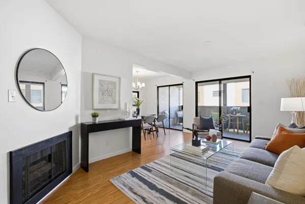 a living room with furniture a rug a fireplace and a large window