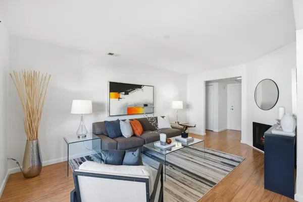 a living room with furniture and a wooden floor