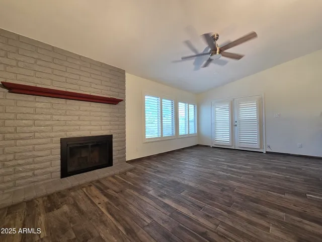 a view of empty room with wooden floor and fireplace