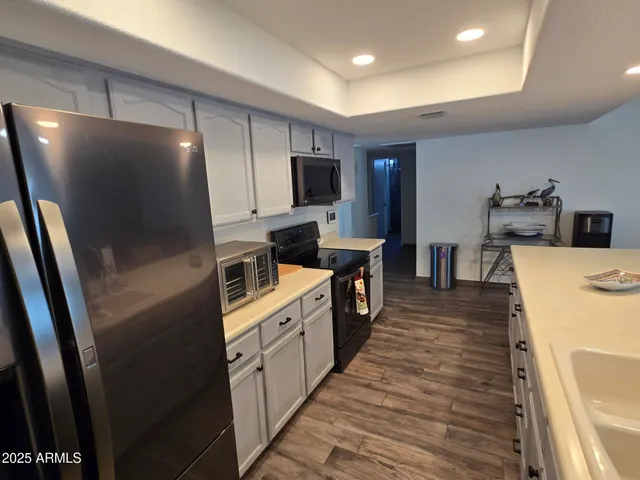 a large kitchen with stainless steel appliances a refrigerator and a stove