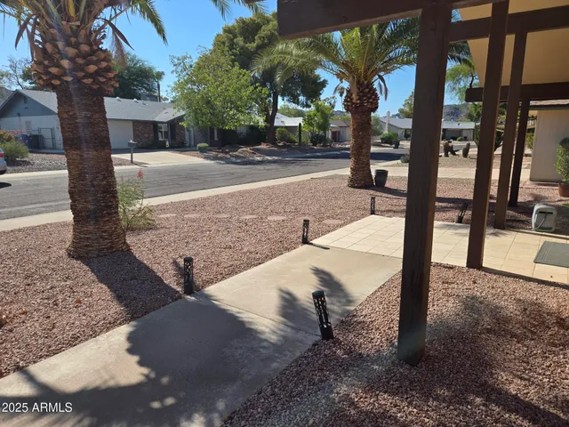 a view of a patio with a table and chairs and floor to ceiling window