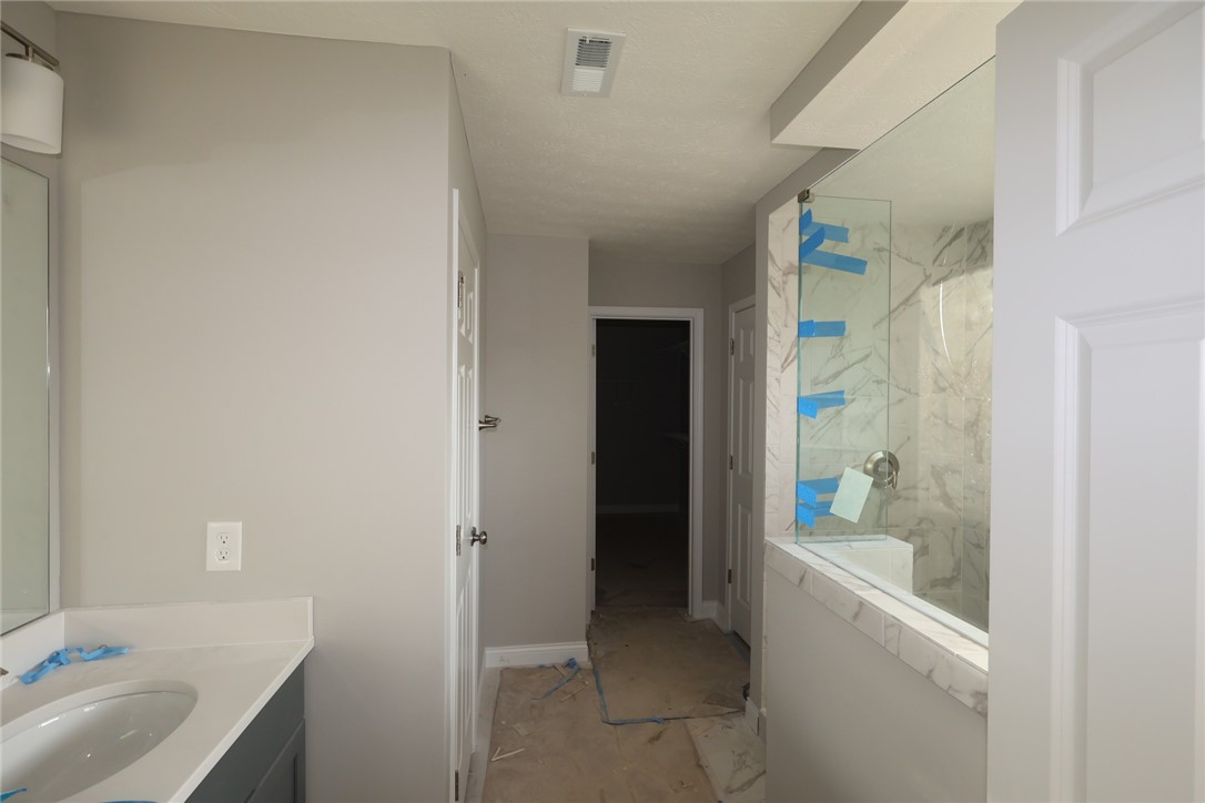 230 Tilly Court, Unit 4 Springboro, OH 45066 - Photo 17 of 20 This modern bathroom features a stylish vanity and a spacious shower with sleek glass panels.