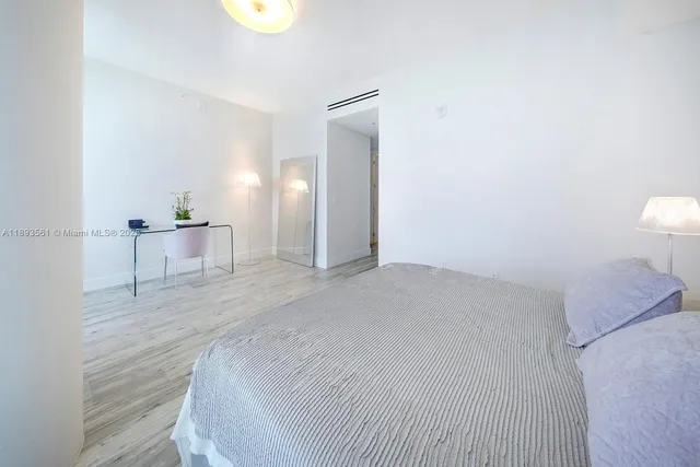 a spacious bedroom with a bed and cabinets