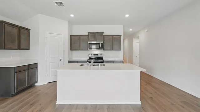 a kitchen with stainless steel appliances a sink stove and refrigerator